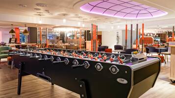 Un tavolo da calcio inglese in un ambiente interno moderno con pavimento in legno e illuminazione soffusa.