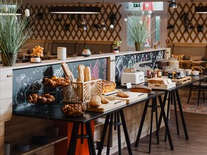 A bakery counter with various breads, pastries, and jars of spreads. - Mercure Lille Aeroport (Lesquin)