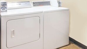 Eine weiße gewerbliche Waschmaschine mit Bedienfeld und Tür, frontal abgebildet.