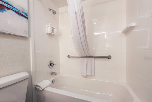 A modern bathroom with a bathtub, a shower curtain, and a towel rack.