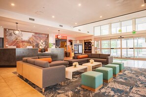 A hotel lobby with seating areas, a reception desk, and a large window offering a view. - La Quinta Inn & Suites by Wyndham Danbury (Danbury)