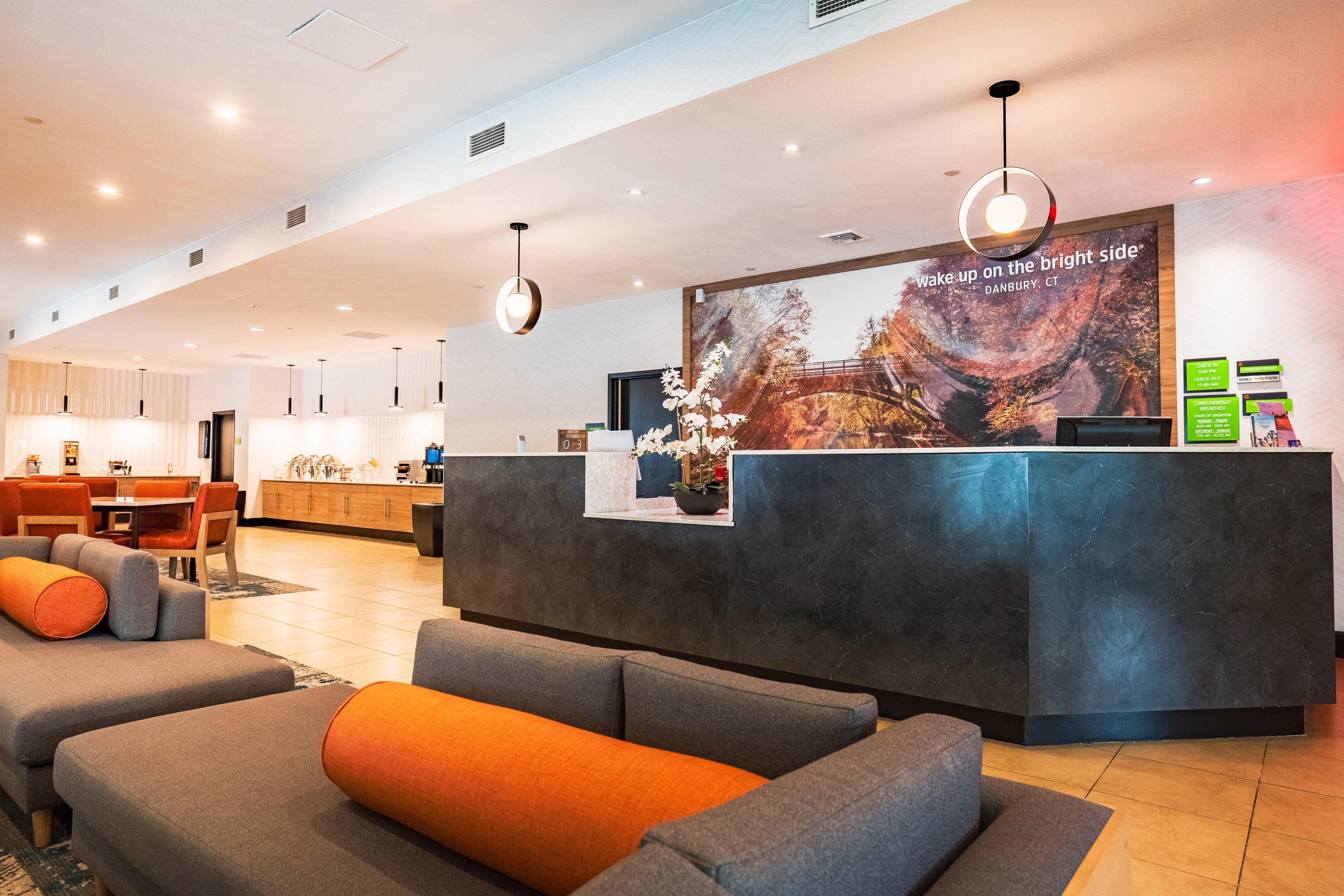 Un hall d’hôtel comprenant un comptoir d’accueil, un espace salon et une grande fenêtre offrant une vue panoramique.