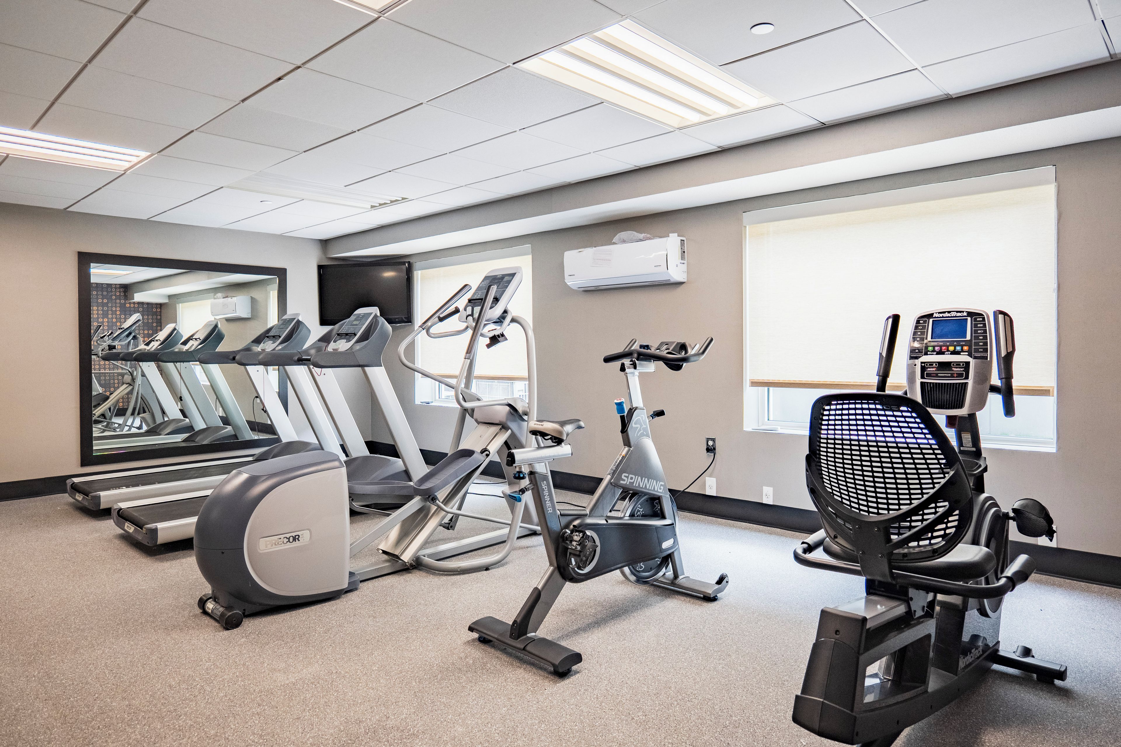 A gym with treadmills, stationary bikes, and a rowing machine.