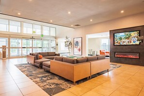 A spacious lobby with a sectional sofa, a fireplace, and a large window overlooking the outdoors. - La Quinta Inn & Suites by Wyndham Danbury (Danbury)