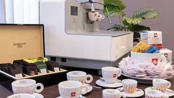 A coffee station with a coffee machine, various coffee pods, and a selection of cups and saucers.