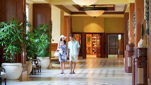 A spacious lobby with a tiled floor, large potted plants, and a grand chandelier. - Hilton Grand Vacations Club Grand Waikikian Honolulu (Honolulu)