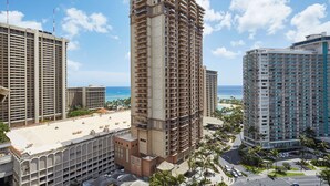 Un hôtel de grande hauteur doté de nombreux balcons, offrant une vue sur la plage et disposant d’un parking.