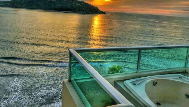 Un balcón con vistas al mar y al atardecer.
