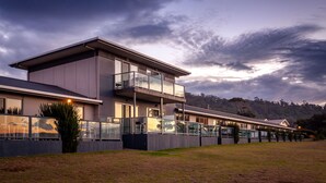 A modern building with a flat roof, large windows, and a balcony. - Beachfront At Bicheno (Bicheno)