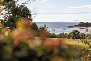 A coastal landscape with a road leading to the sea, boats, and rocky outcrops.