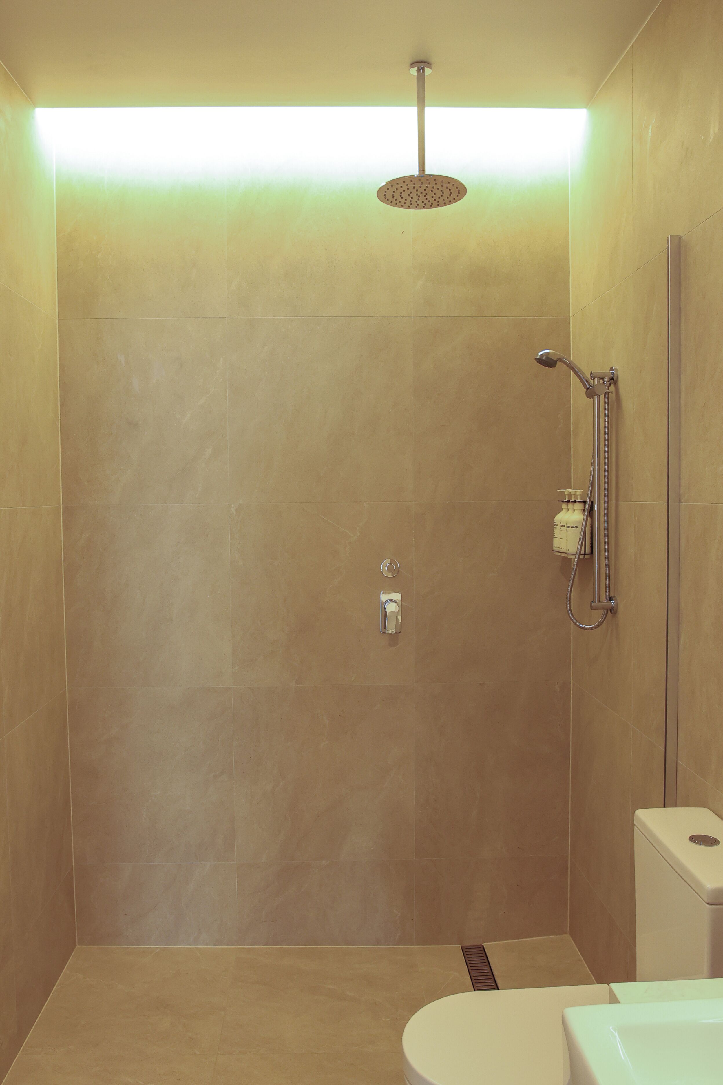 Eine moderne Dusche mit Handbrause und Armaturen an der Wand.