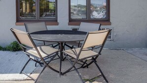 A round table with four chairs, positioned outside a building with large windows. - Days Inn by Wyndham West Allis/Milwaukee (Milwaukee)