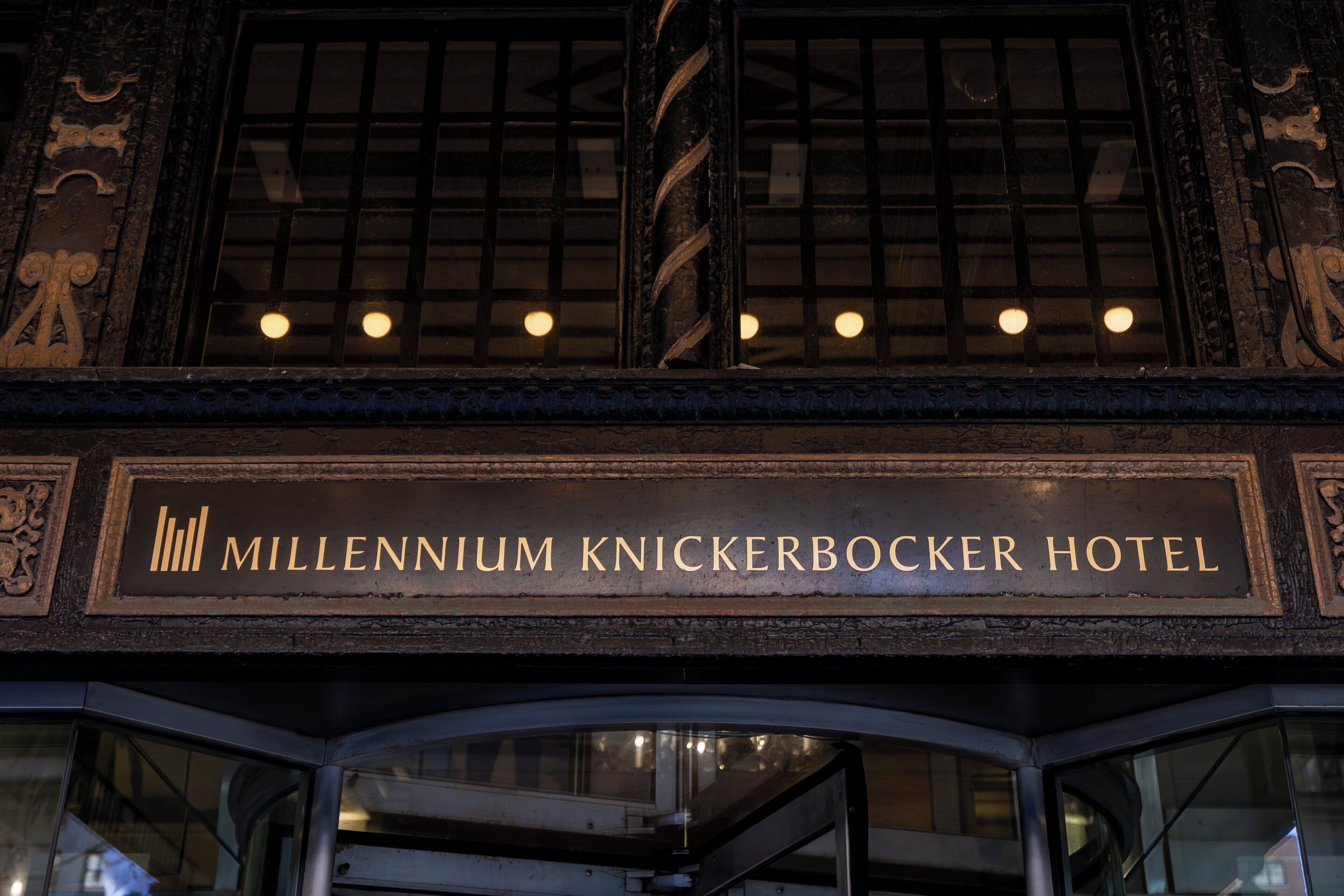 The exterior of the Millennium Knickerbocker Hotel with a sign above the entrance.