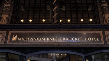 The exterior of the Millennium Knickerbocker Hotel with a sign above the entrance.