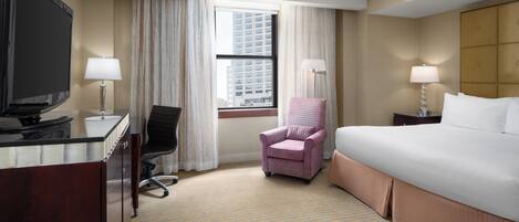 Une chambre d’hôtel équipée d’un lit, d’un bureau, d’une chaise et d’un téléviseur.
