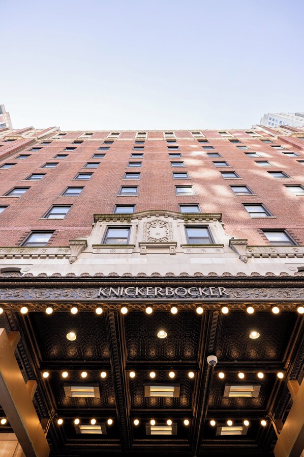 A building with a brick facade, multiple windows, and a sign reading 'KNICKERBOCKER.'