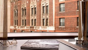 Vista de un edificio de ladrillo con ventanas ornamentadas y un libro titulado 'CHICAGO' sobre una mesa.