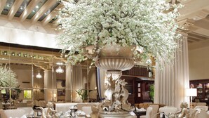 A luxurious lobby with a central fountain, seating areas, and a high ceiling with skylights. - The Drake (Chicago)