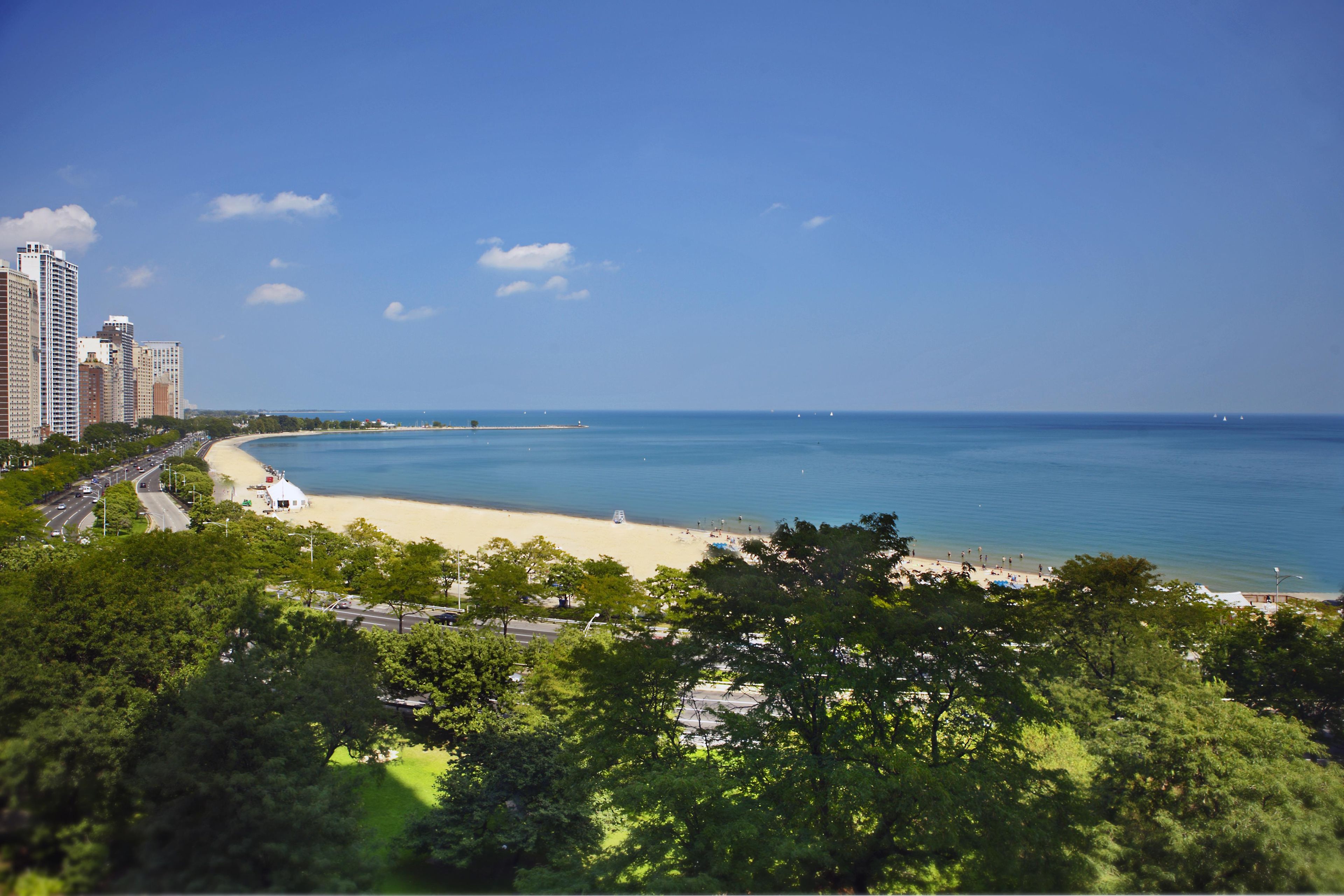 A coastal cityscape with a beach, high-rise buildings, and a clear sky.