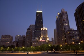 A cityscape with a prominent skyscraper labeled "The Drake" and other surrounding buildings.