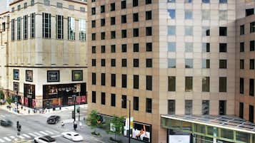 A multi-story building with a modern architectural design, featuring a mix of glass and concrete facades, and a prominent storefront with signage.