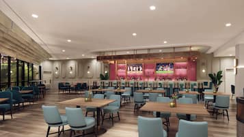 A spacious restaurant with multiple dining areas, a bar with a pink interior, and a large TV screen displaying sports.