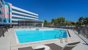 Una piscina al aire libre, camas de piscina gratis, sombrillas