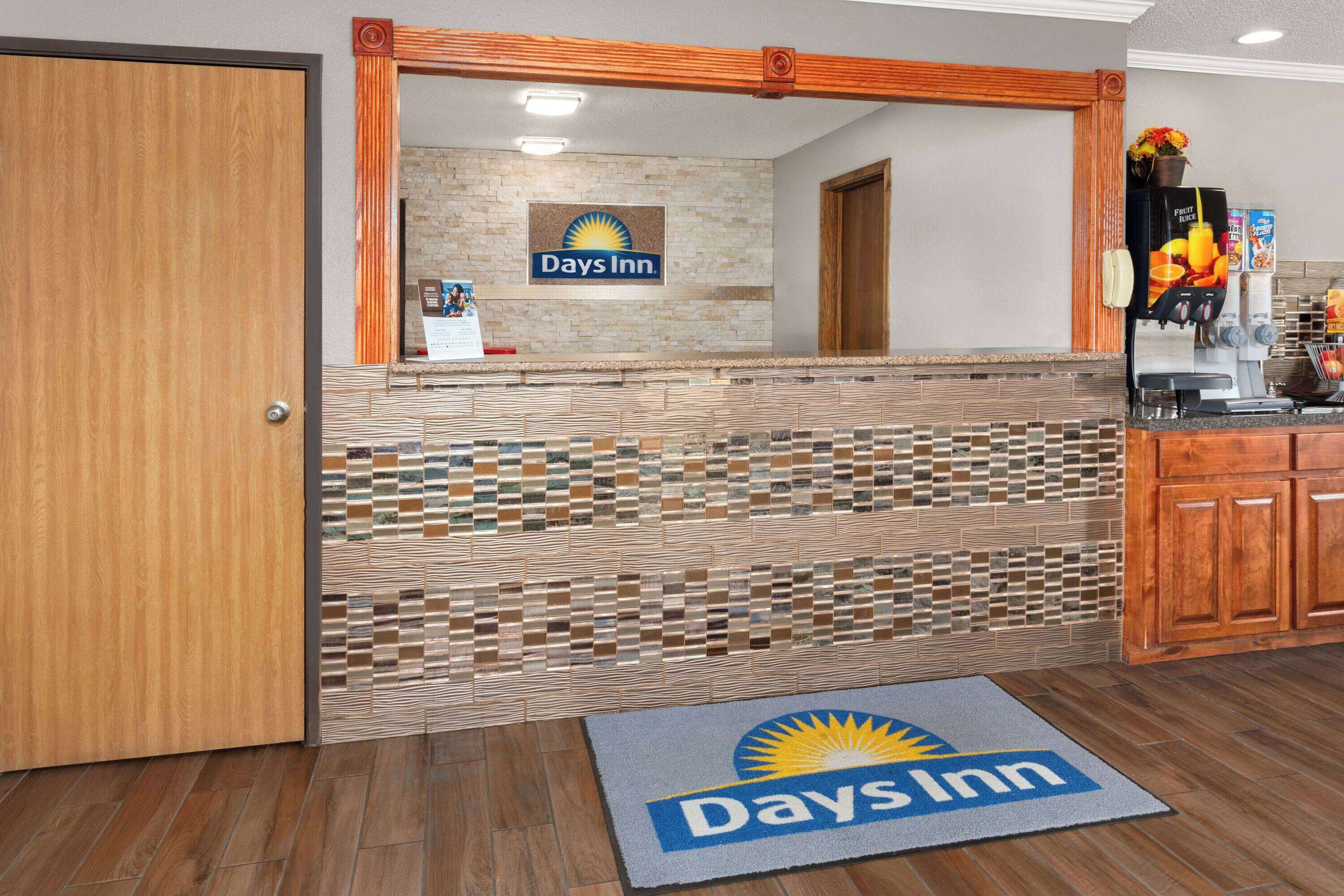 A reception area with a Days Inn sign, a coffee machine, and a wooden cabinet.