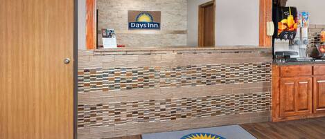 A reception area with a Days Inn sign, a coffee machine, and a wooden cabinet.