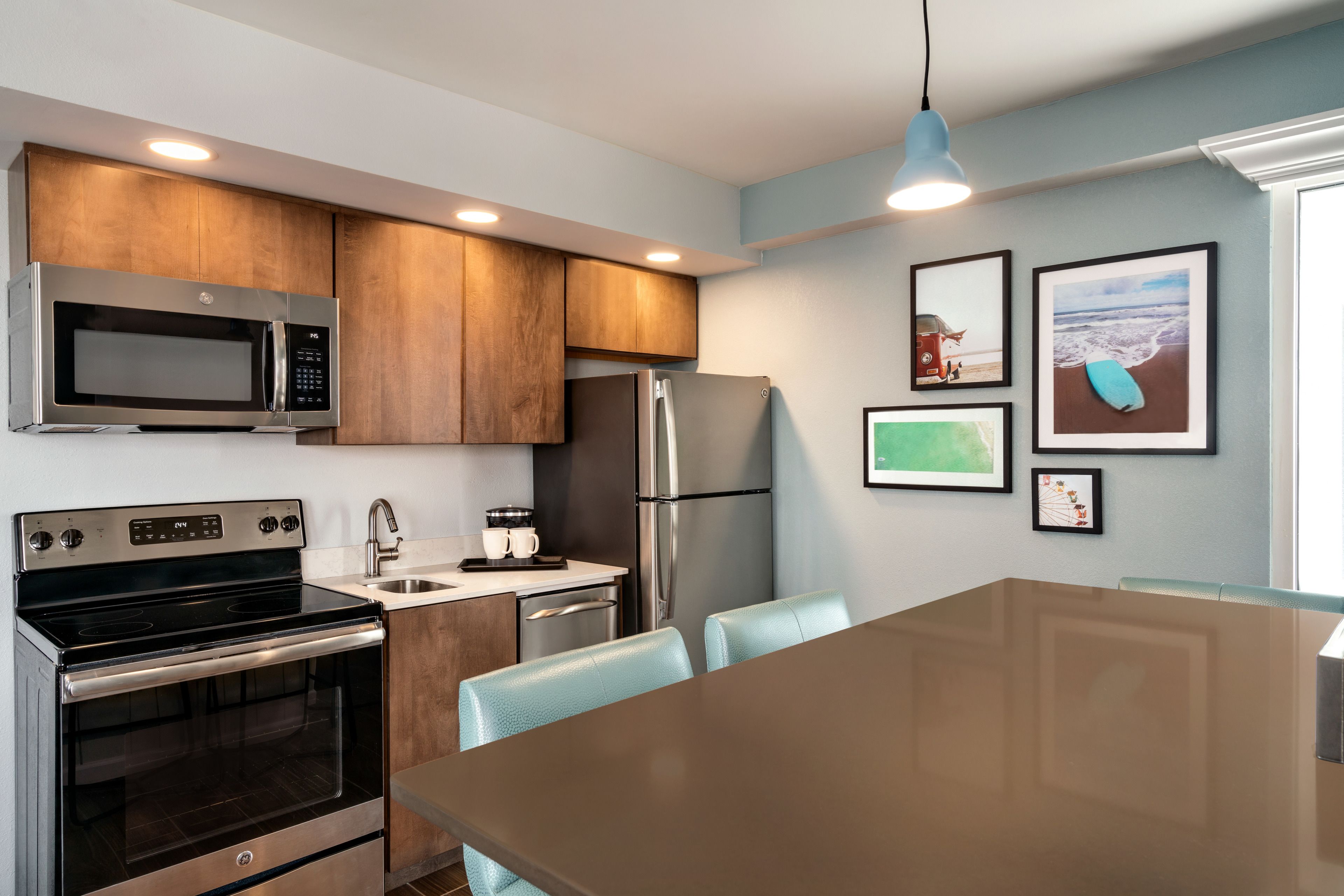 A modern kitchen with stainless steel appliances, wooden cabinets, and a dining area with a large table and chairs.