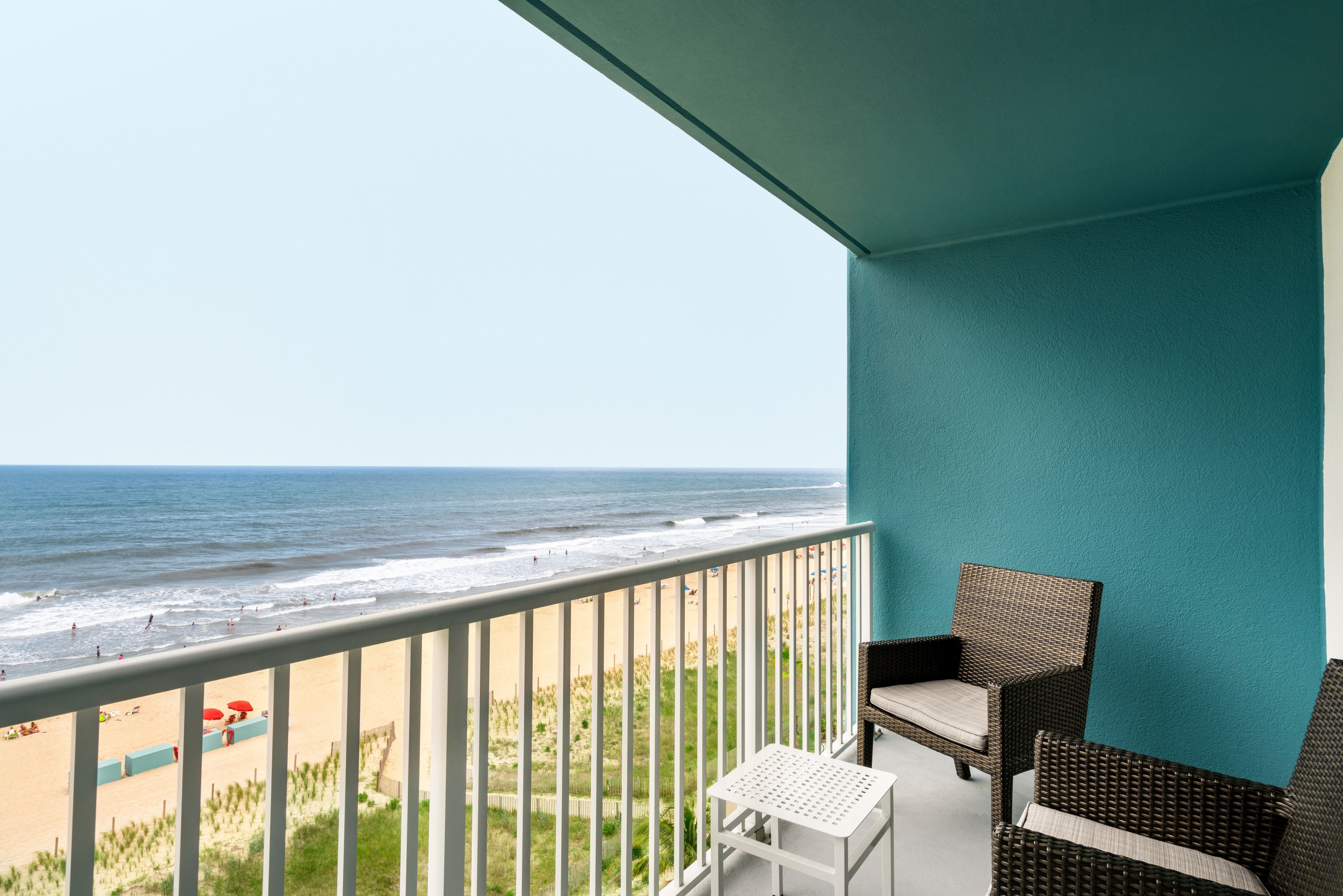 Een balkon met uitzicht op het strand en de oceaan.