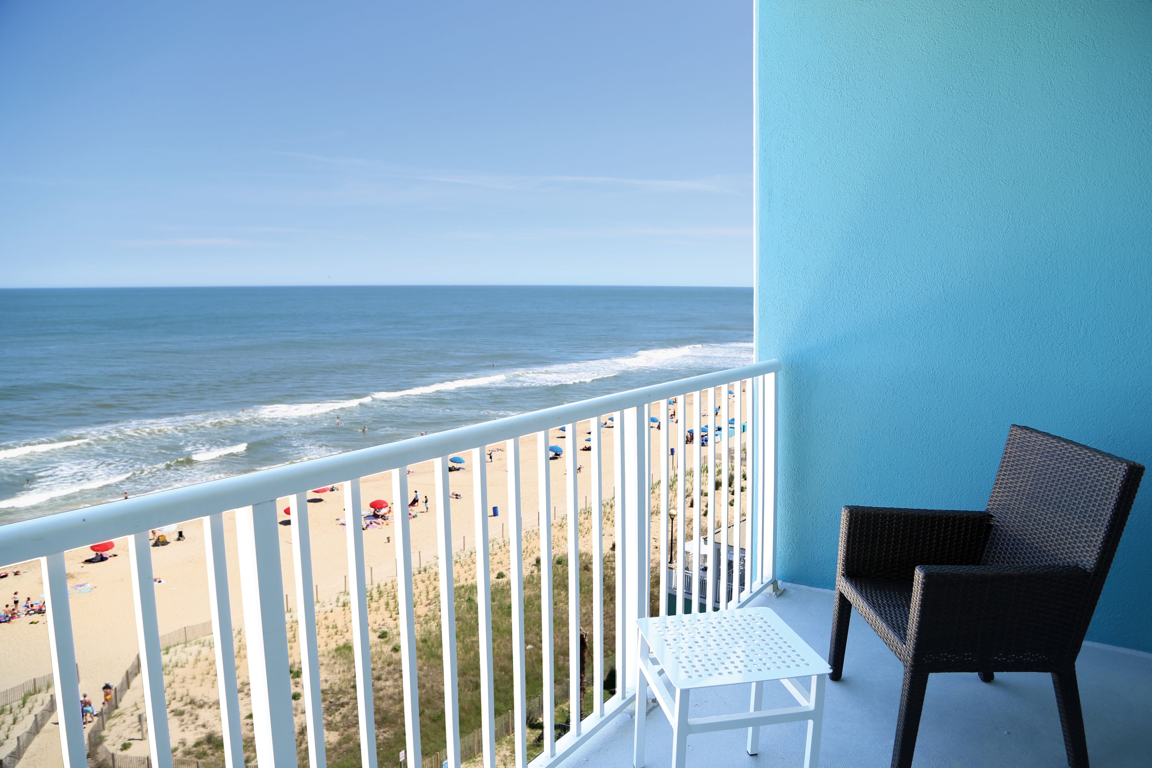 A balcony with a view of the beach and ocean.