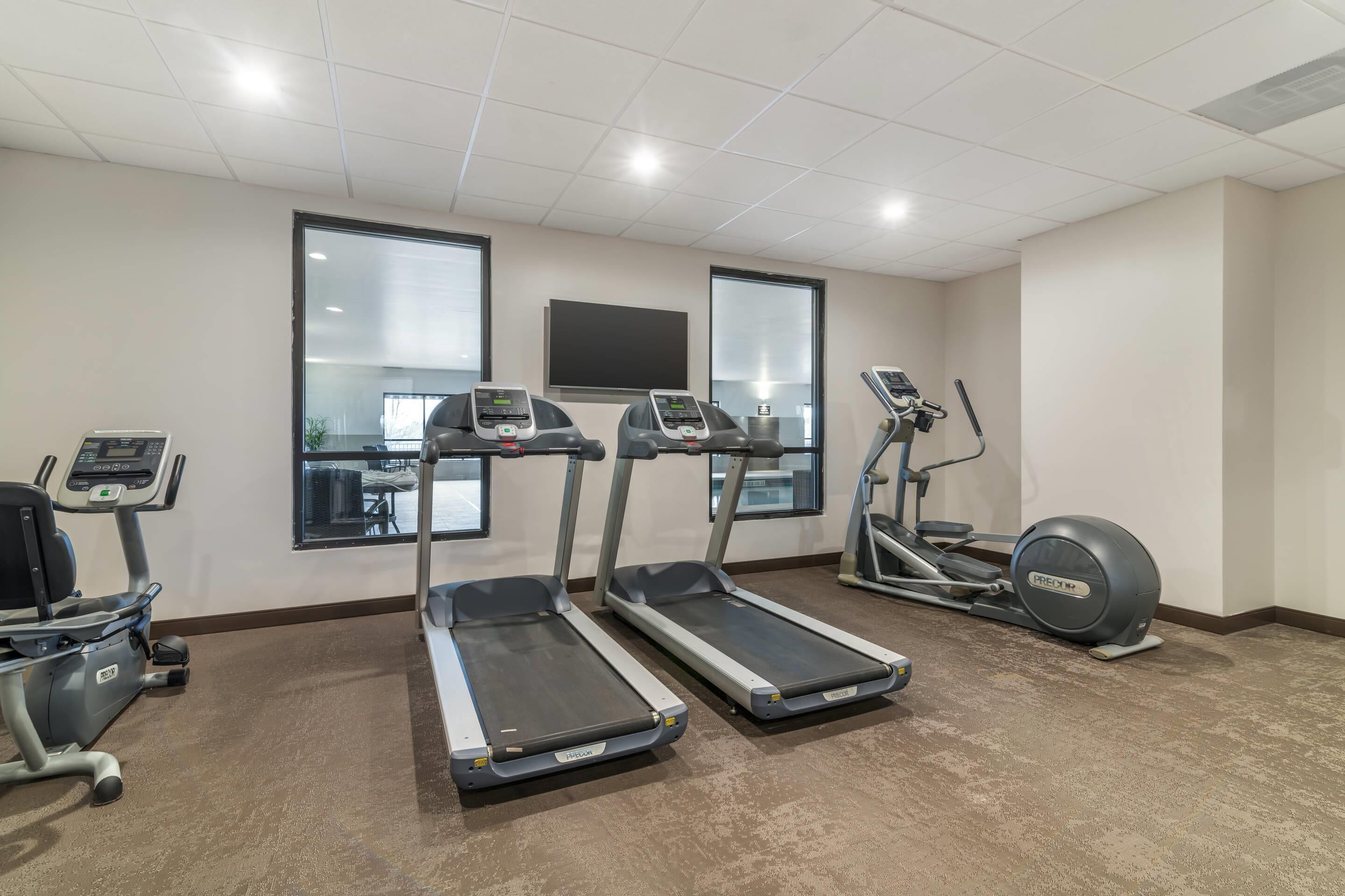 A fitness room with treadmills, an elliptical, and a stationary bike.