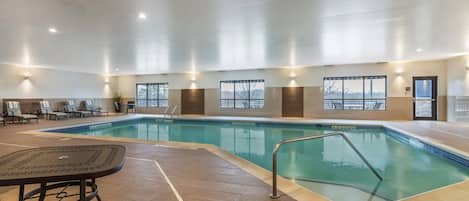 Una piscina techada, sillones reclinables de piscina