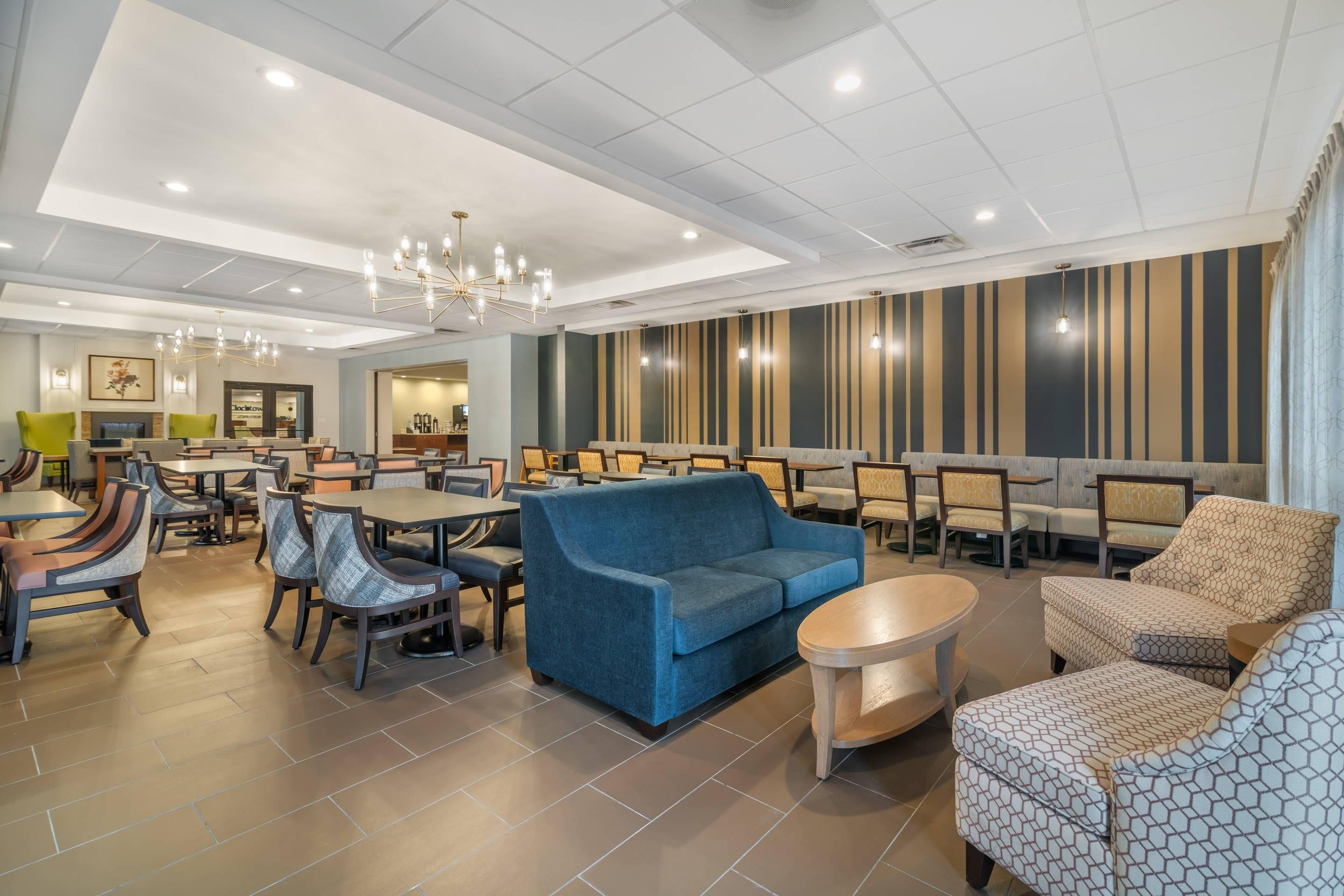 A spacious lobby with seating areas, a chandelier, and a patterned wall.
