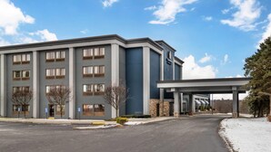 Un hôtel moderne doté d’une grande entrée, de nombreuses fenêtres et d’un parking couvert.
