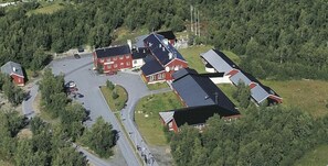 An aerial view of a residential area with multiple houses, a parking lot, and a road. - Lakselv Hotel (Porsanger)
