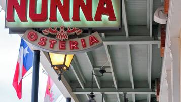 Une enseigne d’hôtel sur laquelle on peut lire « NONNA OSTERIA » et « FAIRMOUNT HOTEL ».