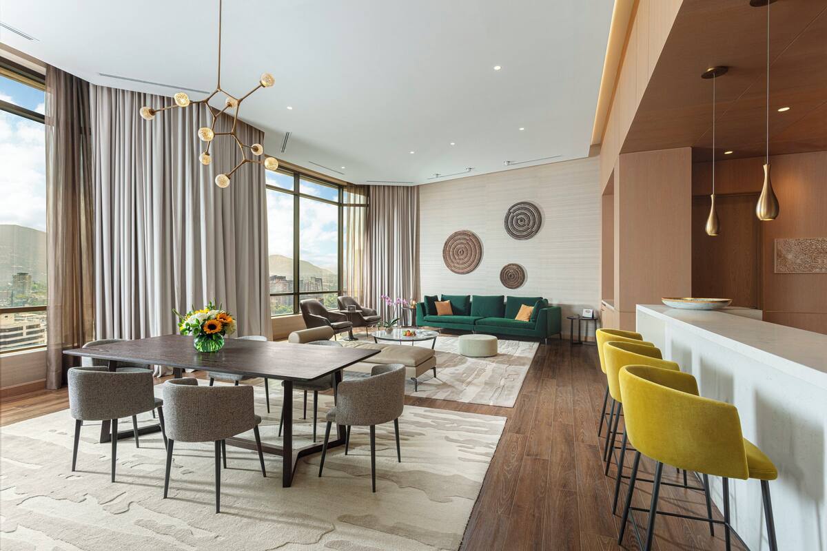 A modern living room with a dining area, a sofa set, and a bar counter.