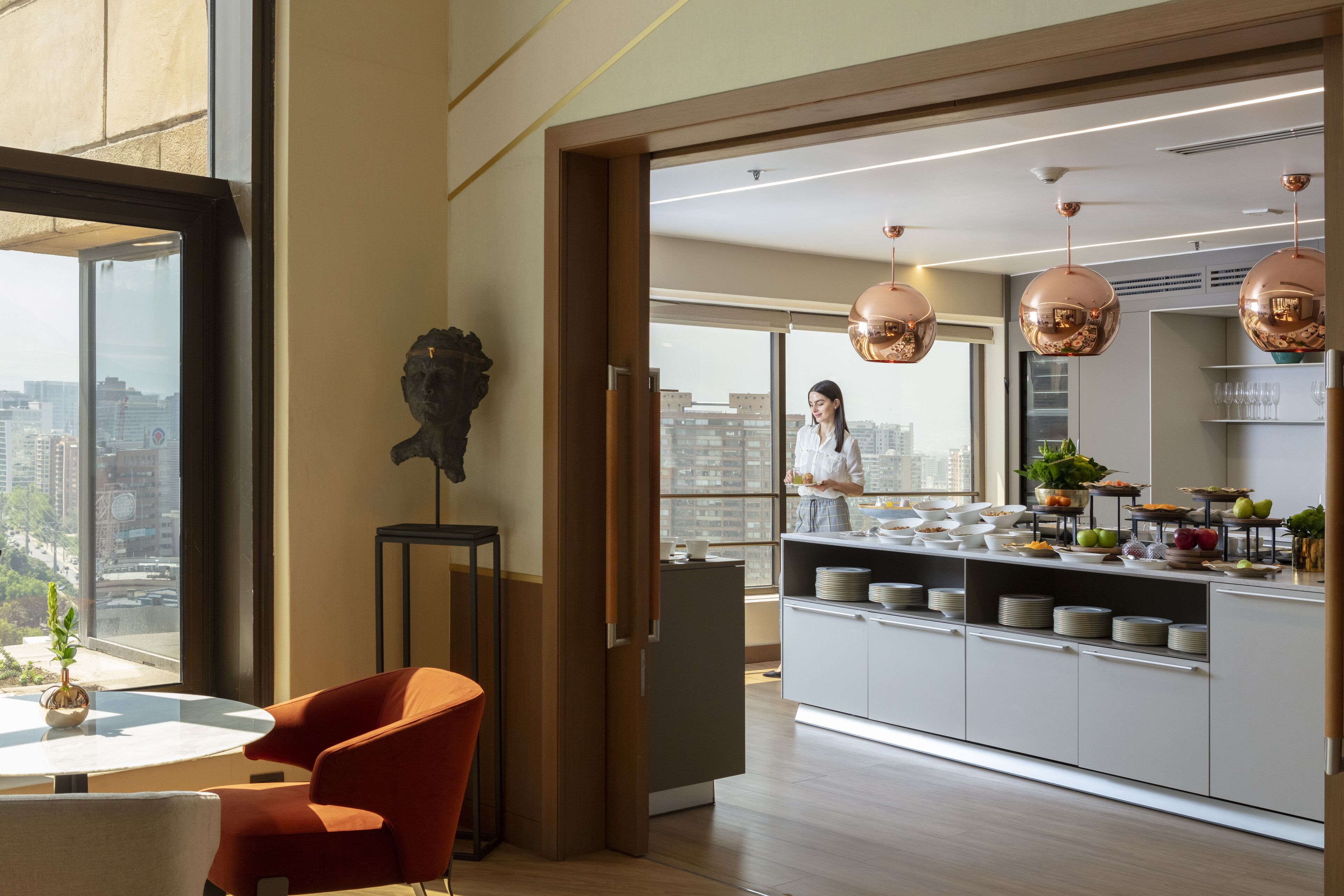 Una cocina moderna con una isla central, ventanas amplias y vistas a la ciudad.