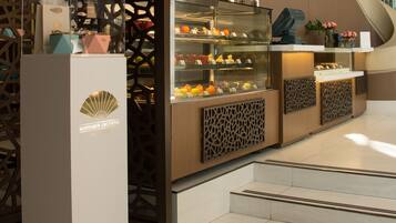 Un hall d’hôtel moderne agrémenté d’une cloison décorative en bois, d’une vitrine exposant divers objets et d’une enseigne indiquant « MANDARIN ORIENTAL ».