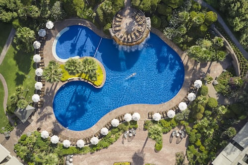 Piscine extérieure en saison, parasols