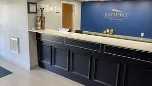 Ein Empfangstresen mit blauer Wand, die das Logo des Baymont Inn & Suites zeigt.