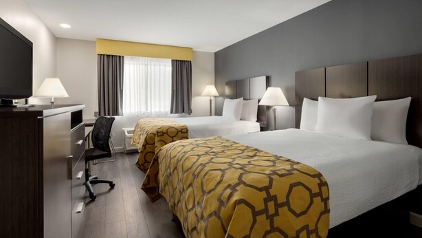 Ein Hotelzimmer mit zwei Betten, einem Schreibtisch und einem Stuhl.