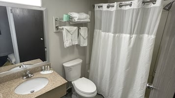 A bathroom with a sink, toilet, and shower curtain.