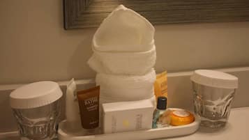 Un mobile bagno con articoli da toilette, tra cui una bottiglia di shampoo, una saponetta e un asciugamano.