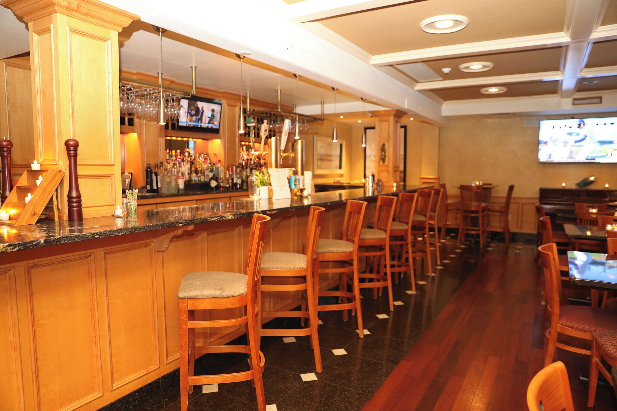 Uma área de bar com cadeiras de madeira e balcão.
