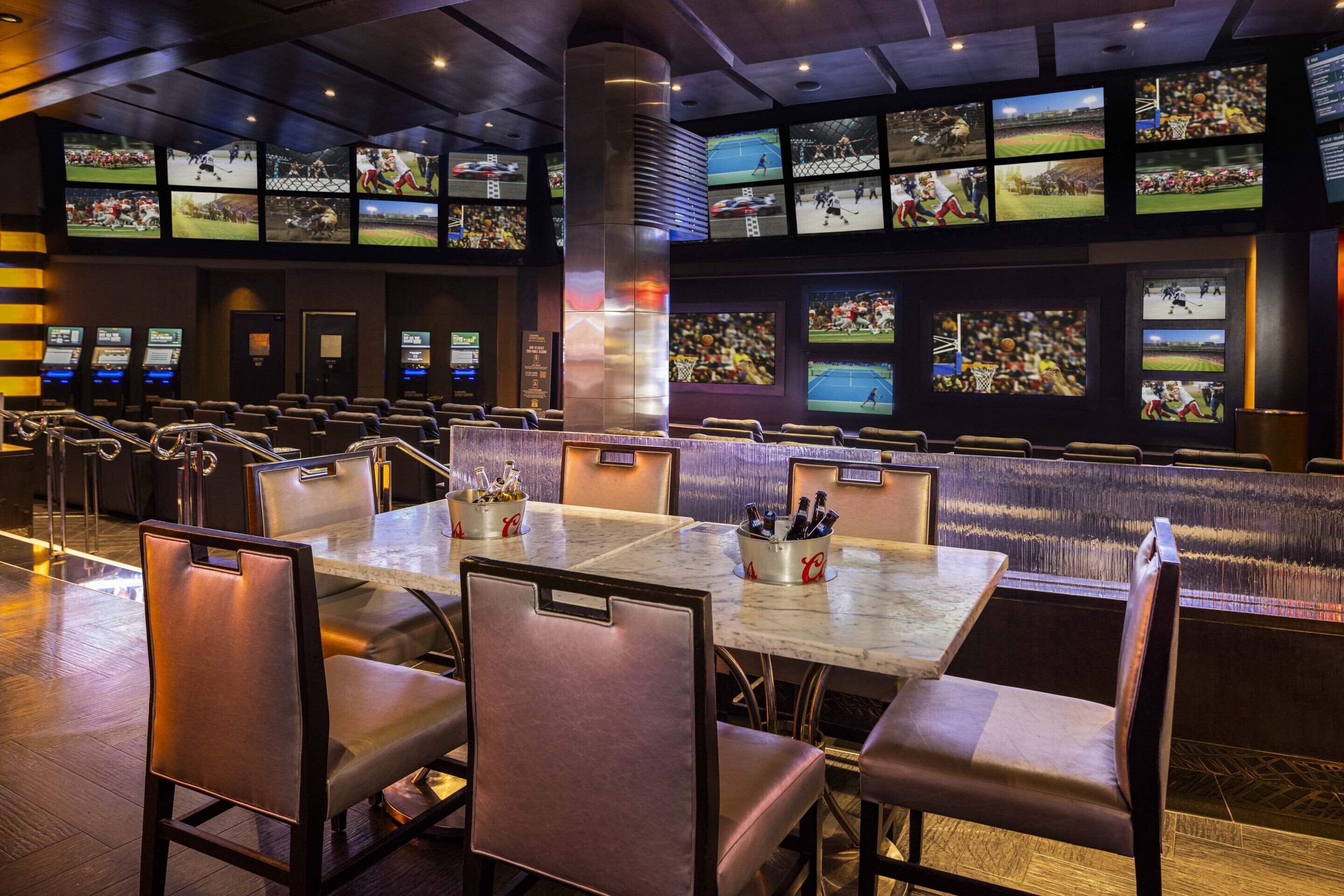 A sports bar with multiple screens displaying various sports events, seating arrangements, and a bar area.