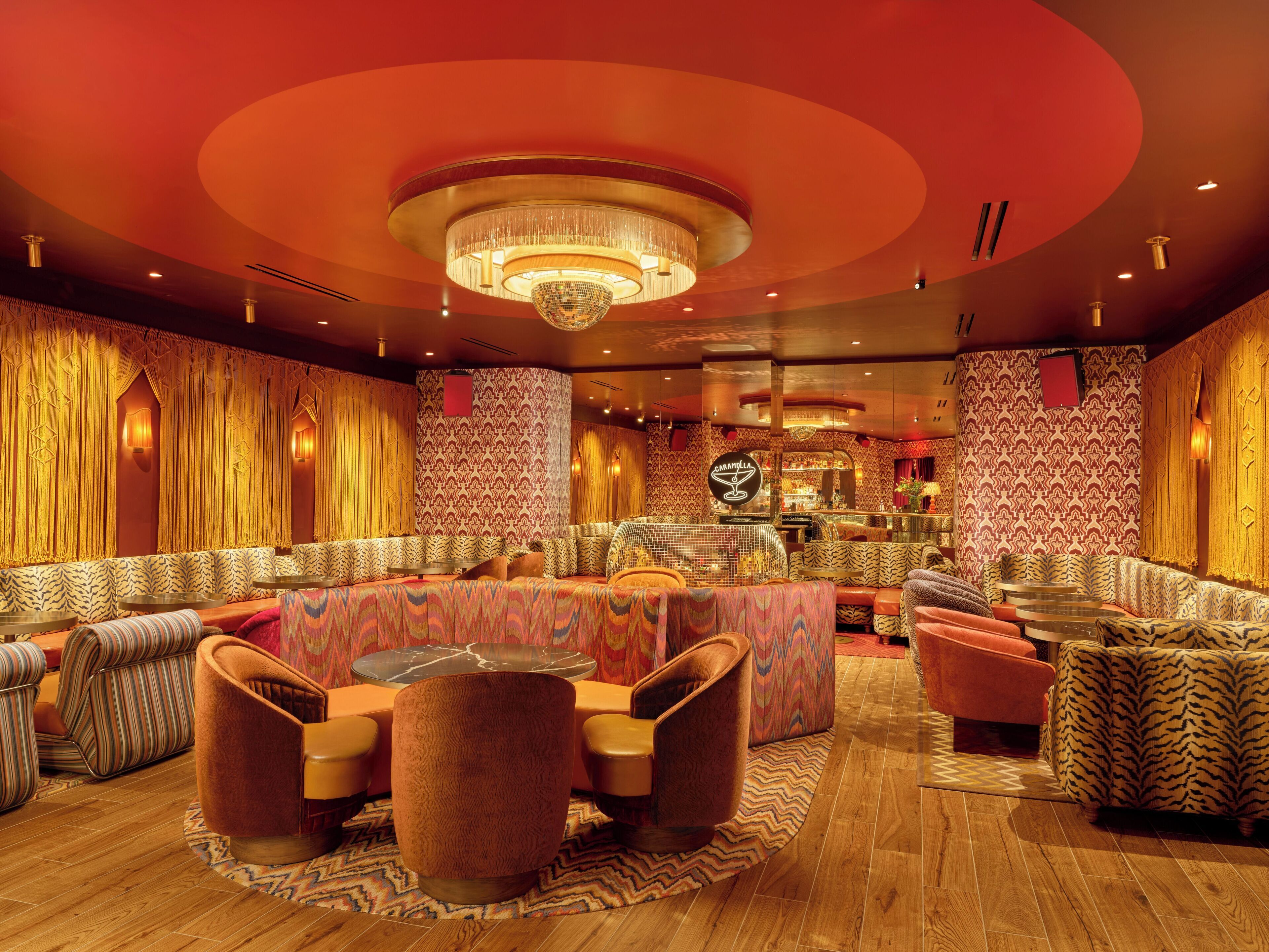 Een sfeervolle lounge met comfortabele zitplaatsen, een bar en een opvallende kroonluchter.
