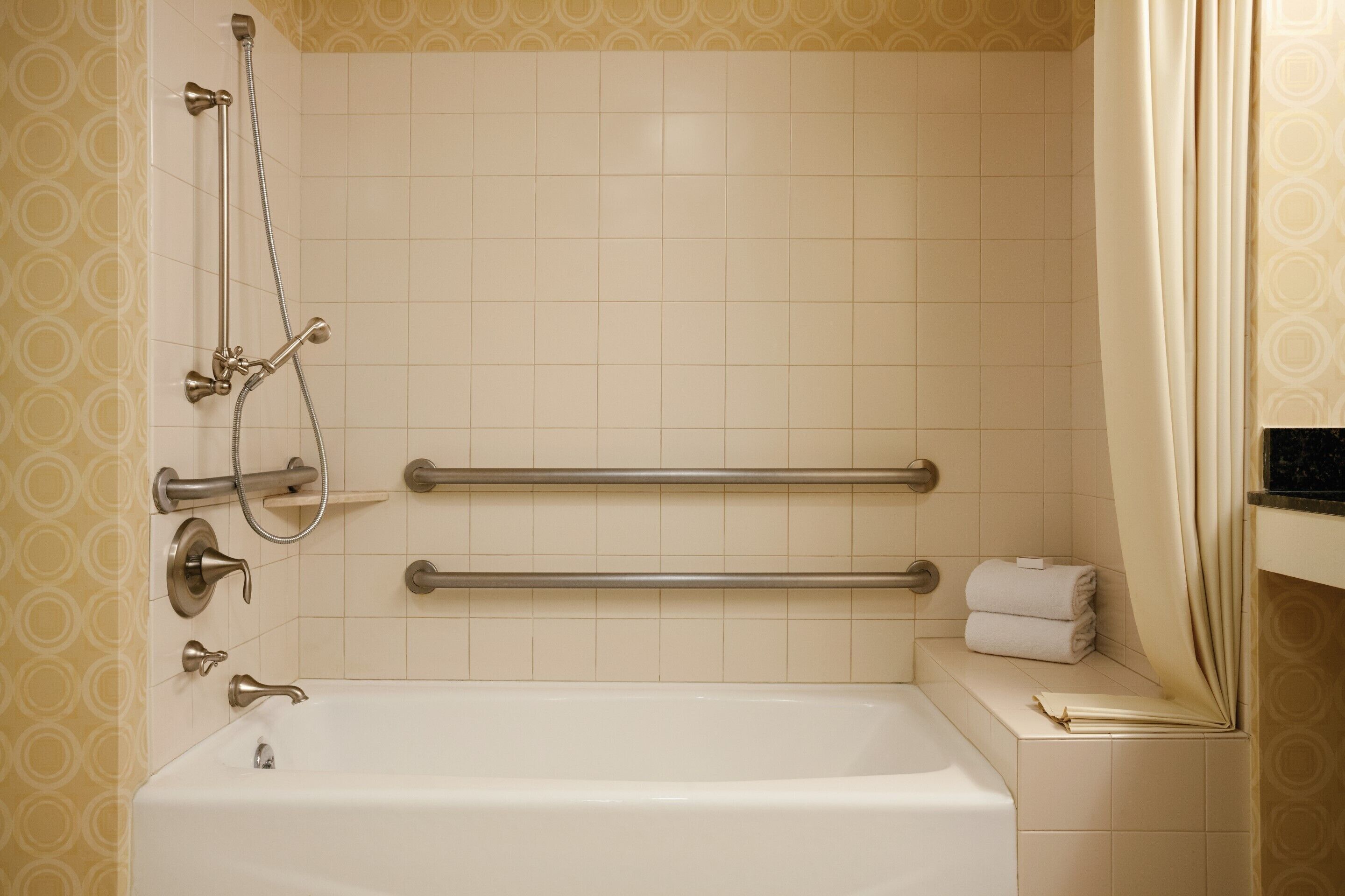 A bathroom with a bathtub, a shower, and a towel rack.